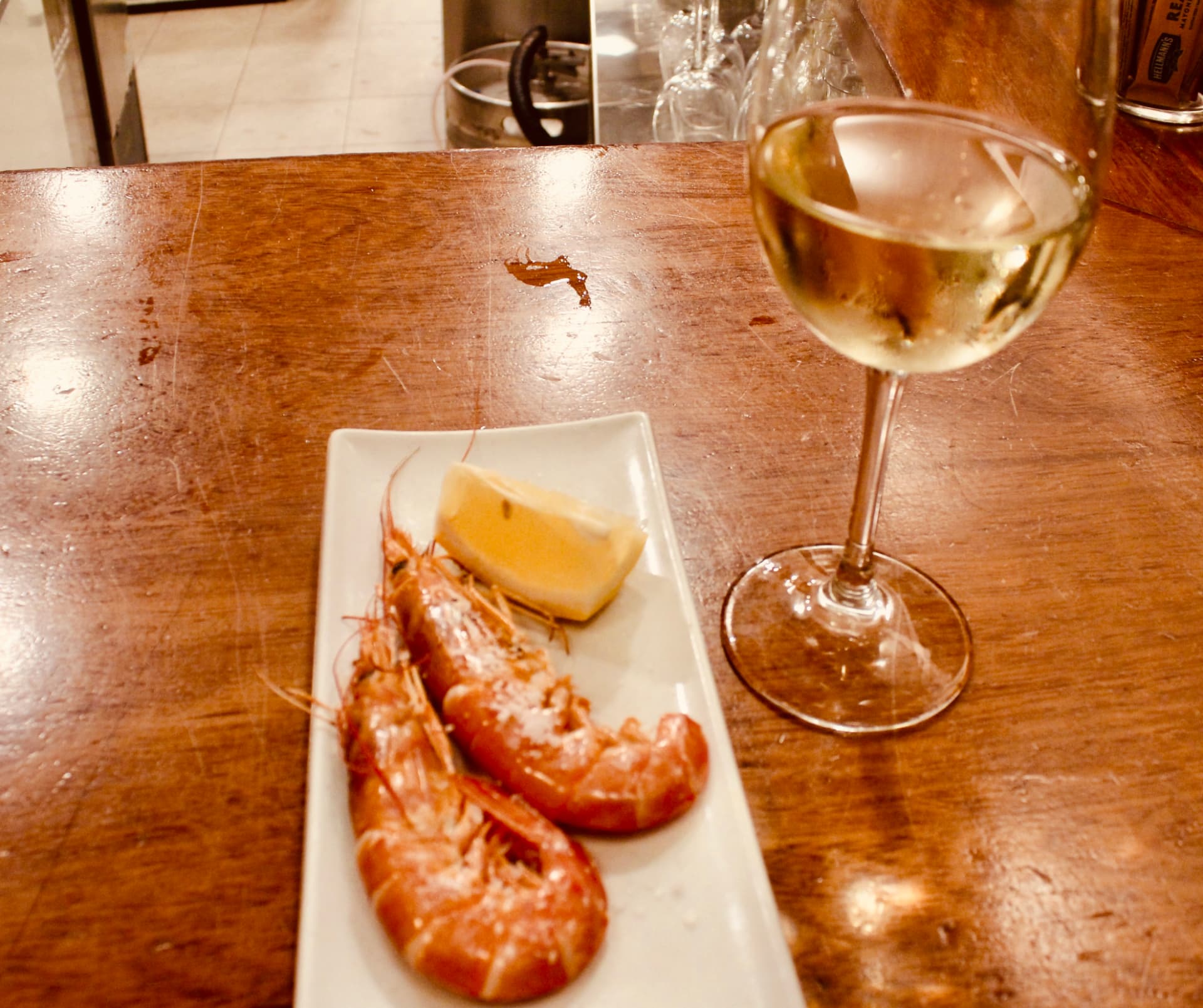 Prawns, lemon and wine shared on a tapas table