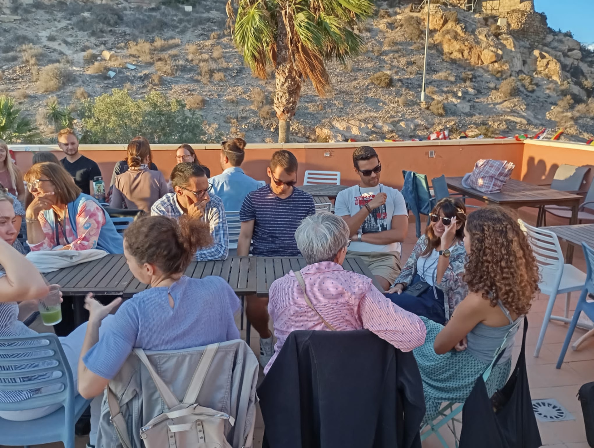 An evening group conversation on a rooftop at golden hour